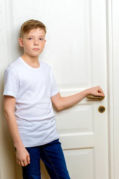 Модный мальчик у белой двери . — стоковое фото