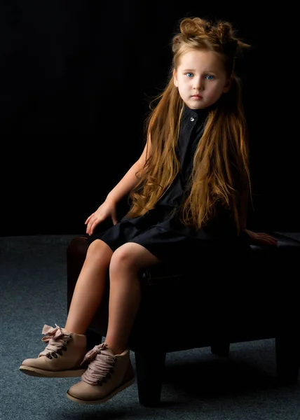 Klein meisje op een zwarte achtergrond — Stockfoto