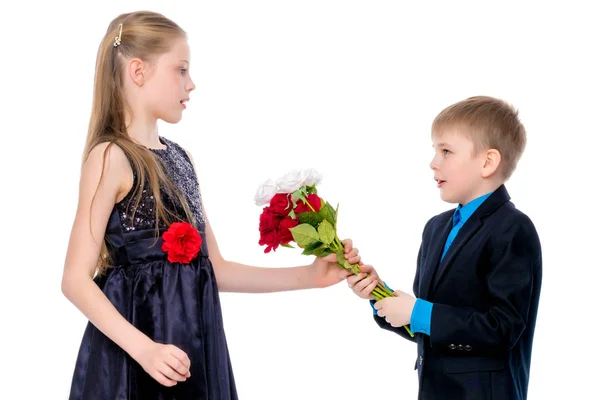 Um menino dá flores à menina . — Fotografia de Stock