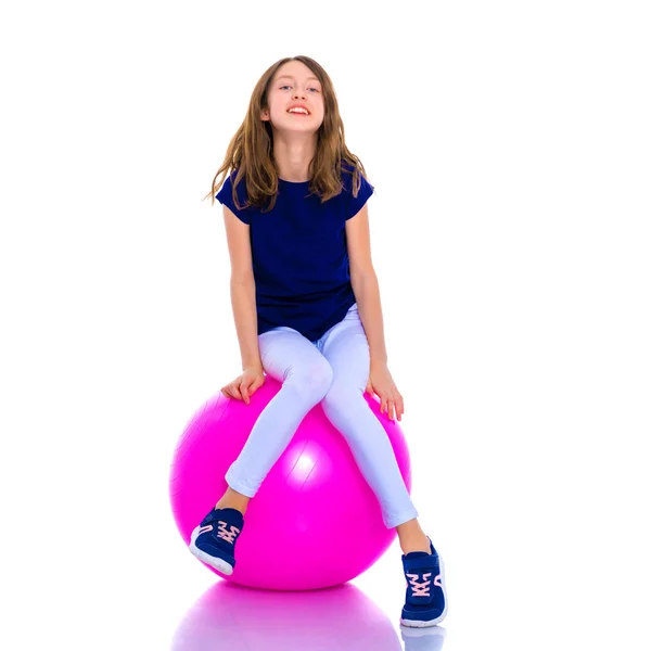 Niña haciendo ejercicios en una pelota grande para la aptitud. —  Fotos de Stock