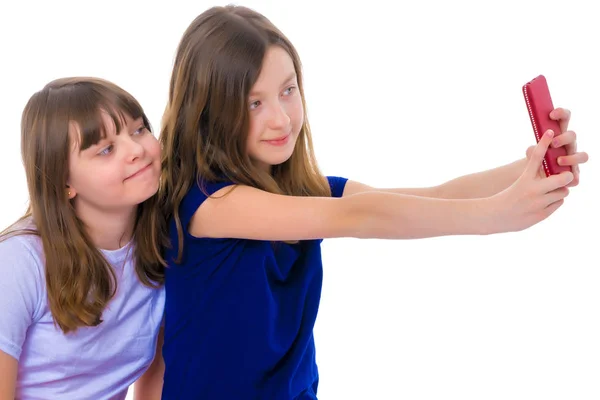 Dos chicas hacen un autorretrato en un smartphone . — Foto de Stock