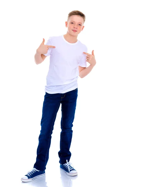 Ein Schuljunge zeigt auf sein weißes T-Shirt. — Stockfoto