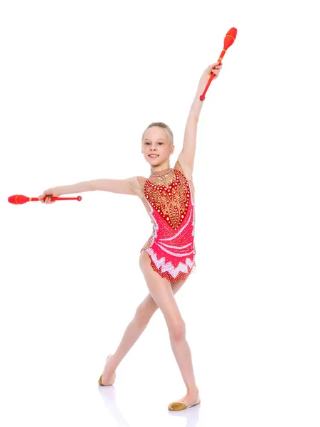 En flicka gymnast utför övningar med en spets. — Stockfoto
