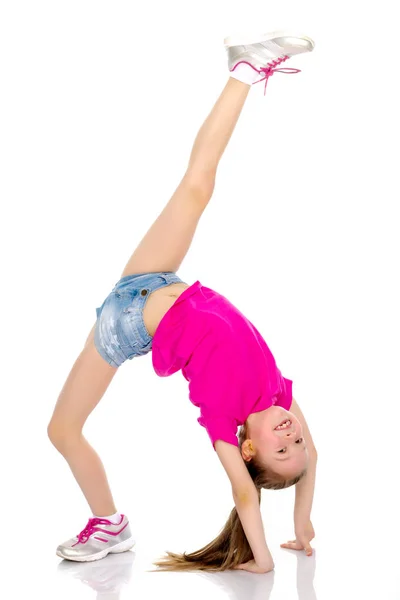 Gymnasten utför en bro med en upphöjd ben. — Stockfoto