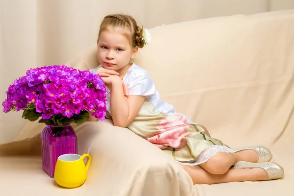 Liten flicka med en bukett blommor — Stockfoto