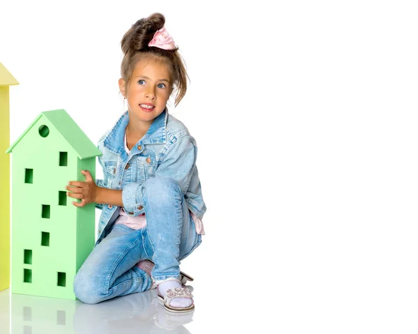 Little girl is playing with wooden houses. — Stock Photo, Image