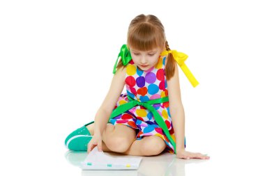 Küçük bir kız kitapçığı okur.