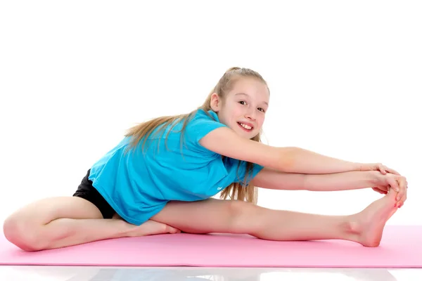 O pequeno ginasta executar um elemento acrobático no chão. — Fotografia de Stock