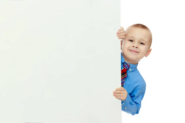 Мальчик выглядывает из-за баннера — стоковое фото