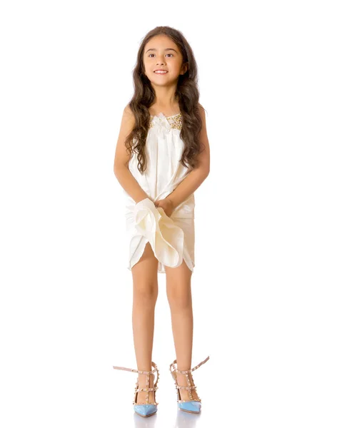 Ein kleines asiatisches Mädchen in hochhackigen Schuhen. — Stockfoto