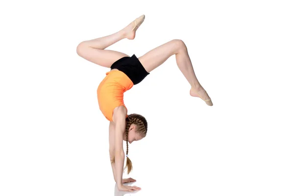 El gimnasta realiza un soporte de mano con las piernas dobladas . — Foto de Stock