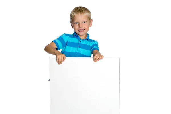 Een kleine jongen is op zoek achter een lege banner. — Stockfoto