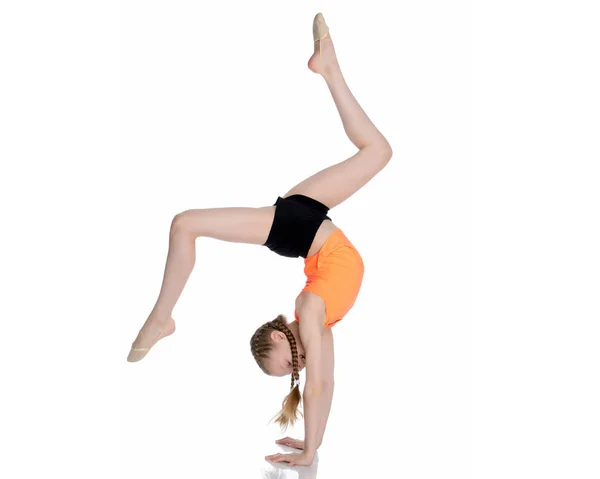 Gimnastyczka wykonuje stojak na rękę z zgiętymi nogami.. — Zdjęcie stockowe