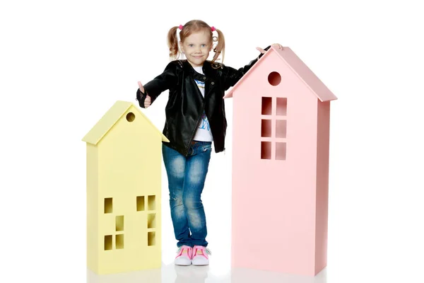 Meisje speelt met houten huizen. — Stockfoto