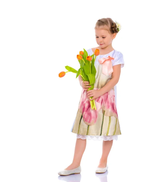 Klein meisje met een boeket tulpen. — Stockfoto