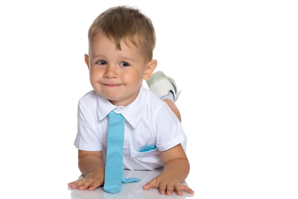 Een kleine jongen is liggend op de vloer in de studio. — Stockfoto