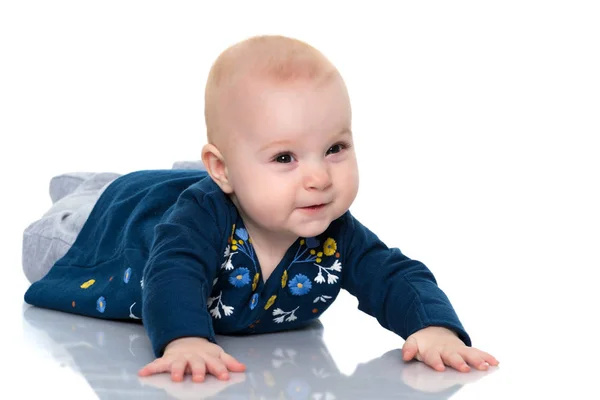 Een leuk, zeer weinig meisje ligt op de vloer op een witte backgr — Stockfoto