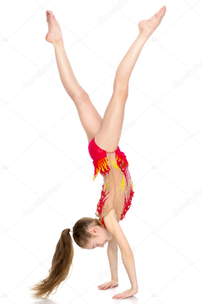 girl gymnast performs a handstand.