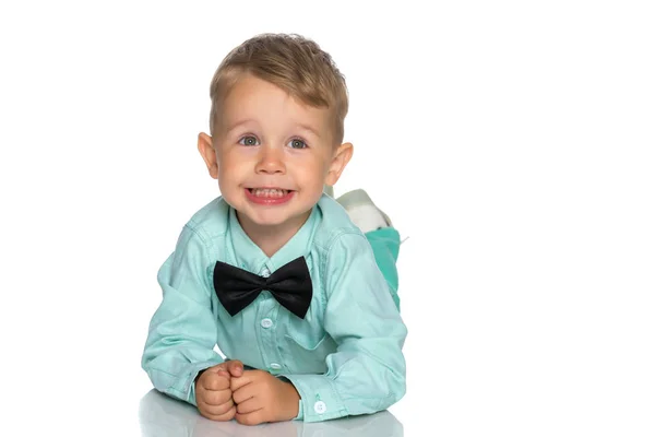 A little boy is lying on the floor in the studio. — Stock Photo, Image