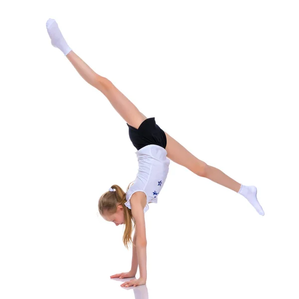 Гимнастка выполняет акробатический элемент на полу. — стоковое фото