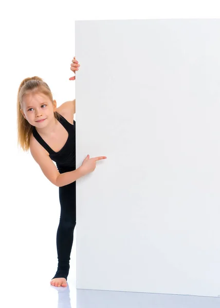 Menina aponta um dedo para um banner branco . — Fotografia de Stock