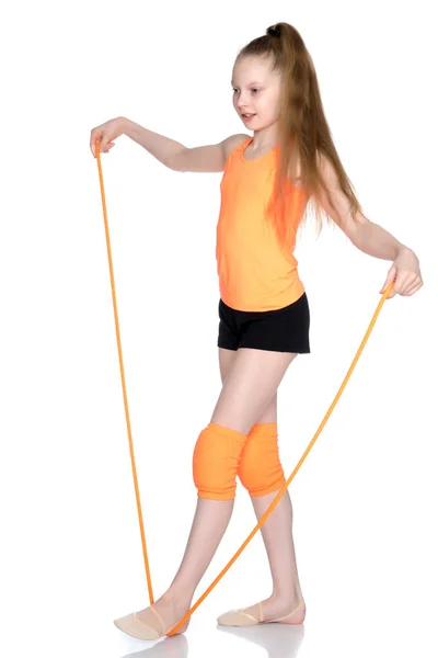 Una chica gimnasta realiza ejercicios con una cuerda para saltar. —  Fotos de Stock