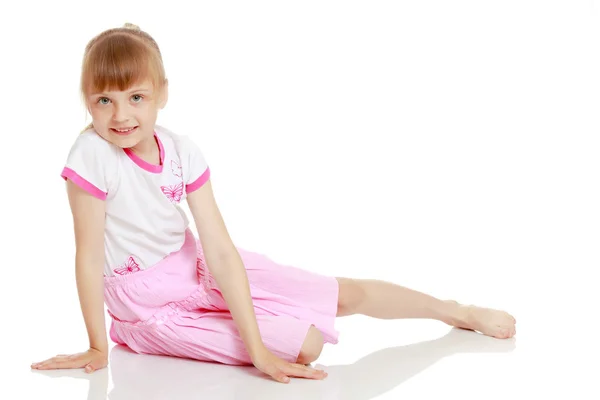 Маленькая девочка сидит на полу. — стоковое фото
