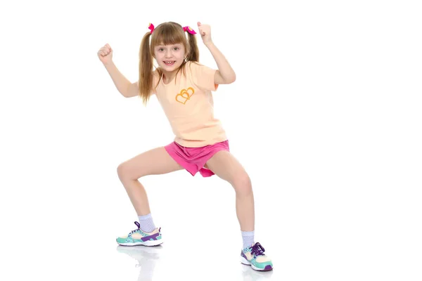 Uma menina faz exercícios de ginástica. — Fotografia de Stock