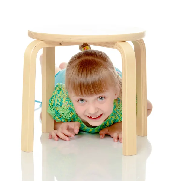 La bambina è seduta su una sedia — Foto Stock