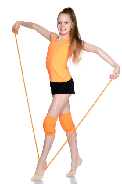 Ένα κορίτσι γυμνάστρια εκτελεί ασκήσεις με ένα σχοινί παρακάμπτοντας. — Φωτογραφία Αρχείου