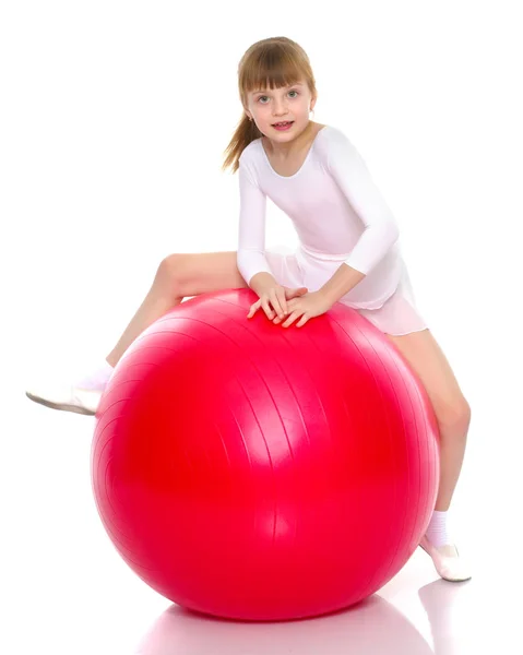 Una niña está saltando en la gran pelota de gimnasia . — Foto de Stock