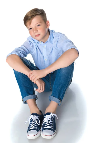 Elegante menino adolescente sentado no chão . — Fotografia de Stock