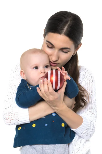 A happy mother is holding a small daughter with a Christmas tree — Stock Photo, Image