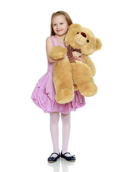 Schöne kleine Mädchen 5-6 Jahre. Sie hält einen großen Teddy Bea — Stockfoto