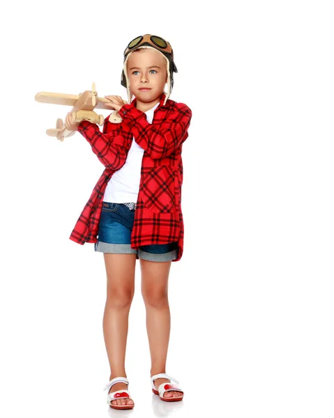 Κοριτσάκι με ένα ξύλινο αεροπλάνο στο χέρι. — Φωτογραφία Αρχείου