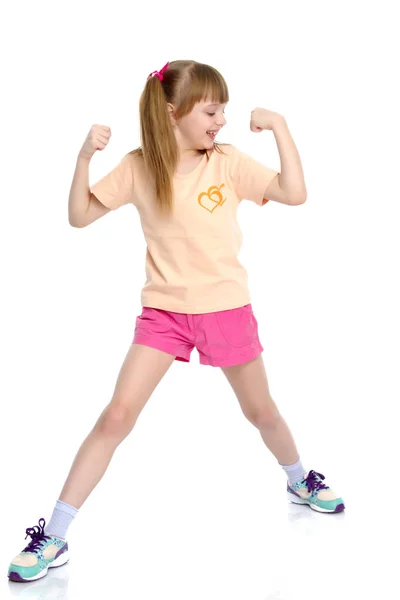 Een klein meisje toont haar spieren. — Stockfoto