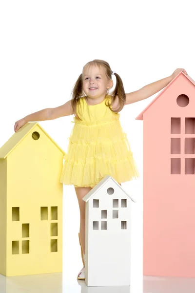 Маленька дівчинка грає з дерев'яними будинками . — стокове фото