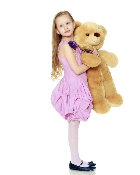 Belle petite fille 5-6 ans.Elle tient un grand bea en peluche — Photo