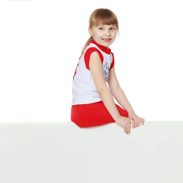 Una bambina sta guardando da dietro uno striscione vuoto. — Foto Stock