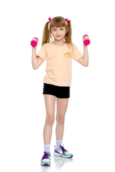 Little girl doing exercises with dumbbells. — Stock Photo, Image