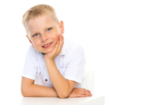 Un petit garçon est assis à la table . — Photo