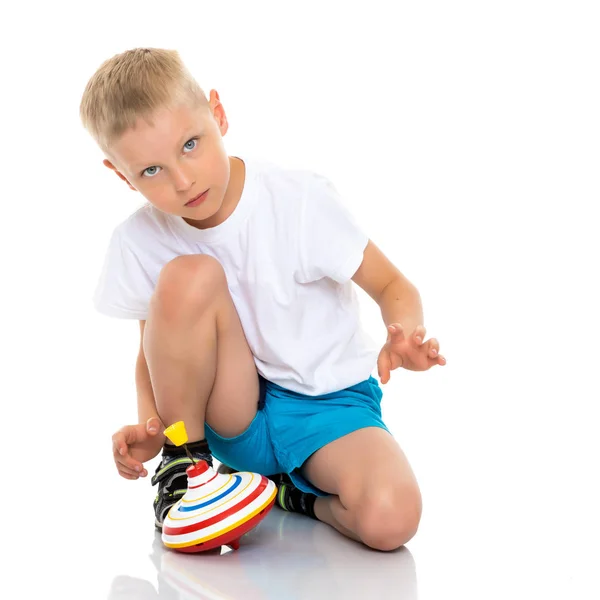 Liten pojke leker med en snurra. — Stockfoto