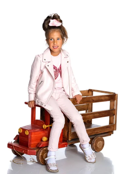 Kleines Mädchen spielt mit einem Holzauto. — Stockfoto