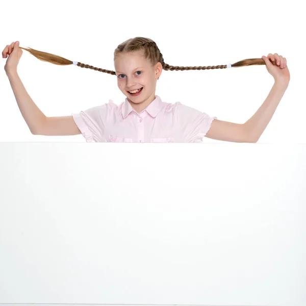 Het kleine meisje trekt zichzelf in pigtails. — Stockfoto