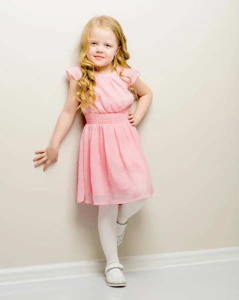 A nice little girl leaned her back against the wall. — Stock Photo, Image