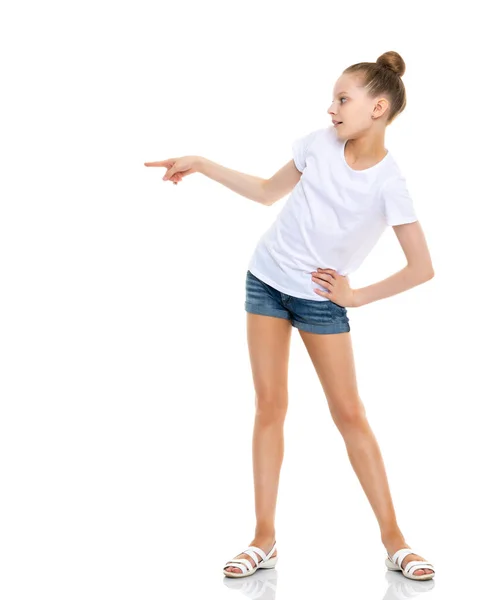 Una niña con una camiseta blanca señala algo.. —  Fotos de Stock