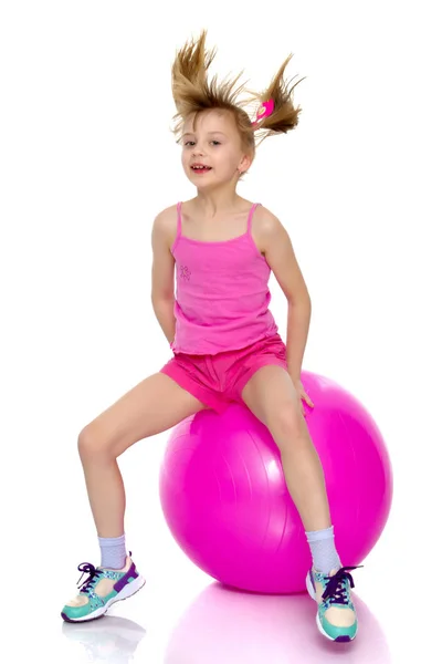 一个小女孩跳上了大体操球. — 图库照片