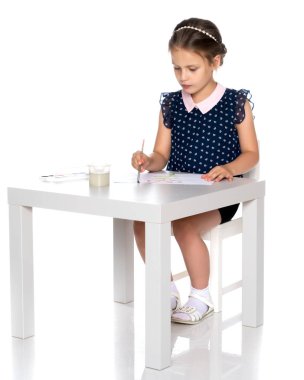 Küçük bir kız boya ve fırça ile boya.