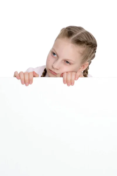 Küçük bir kız boş bir pankartın arkasından bakıyor.. — Stok fotoğraf