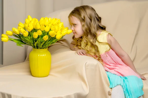 Krásná školačka s dlouhými hedvábnými vlasy s kyticí tulipánů — Stock fotografie
